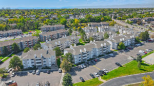 aerial exterior of ascent residential buildings, 3 story walk ups, meticulous landscaping, bbq/picnic area, lush trees planted throughout the property.