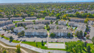 aerial exterior of ascent residential buildings, 3 story walk ups, meticulous landscaping, bbq/picnic area, lush trees planted throughout the property.